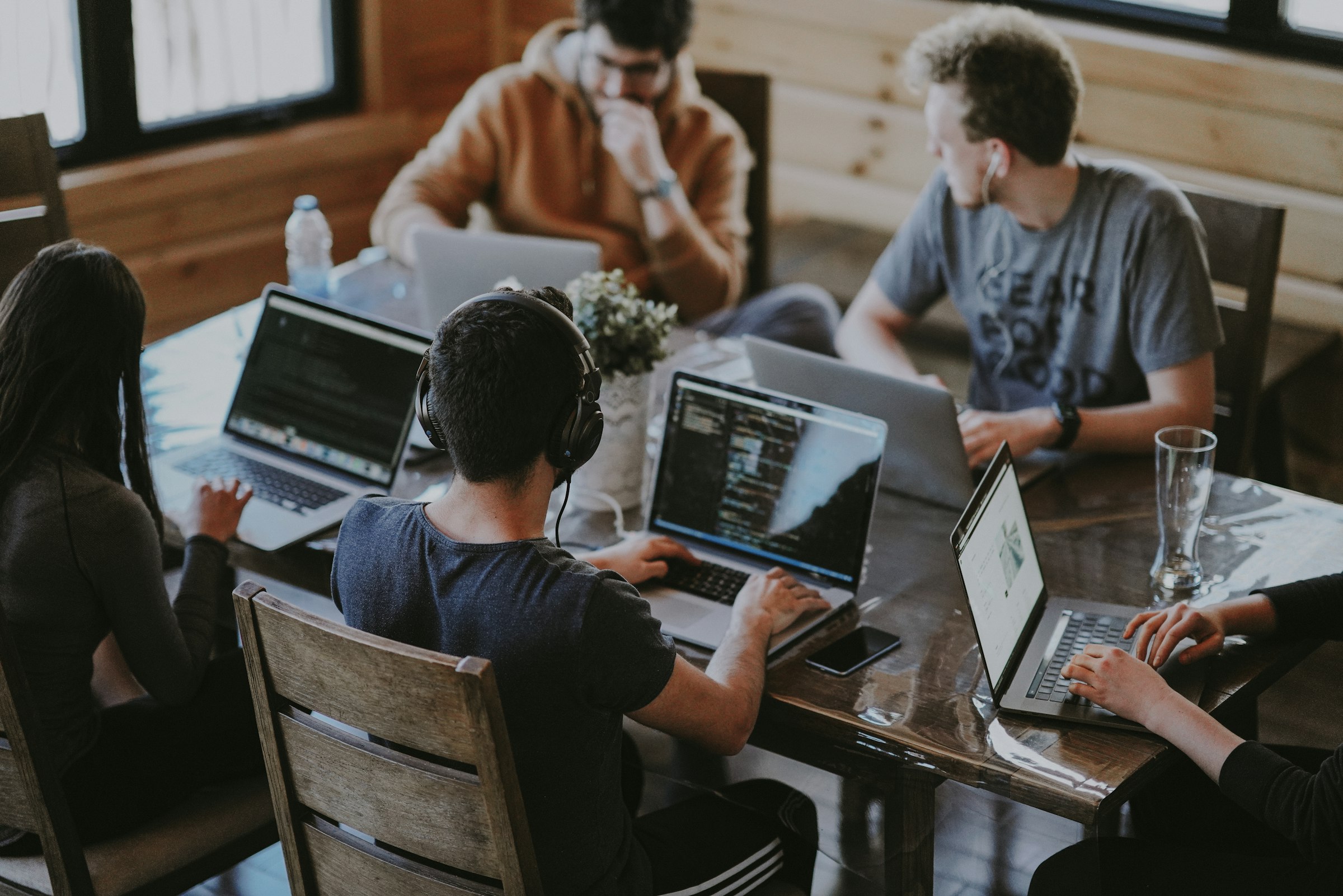 Kollegen arbeiten gemeinsam an Laptops