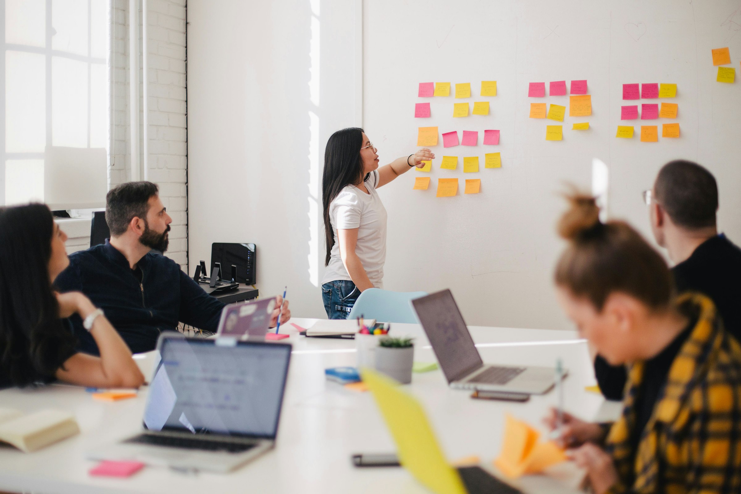 Team im Workshop vor einer Wand voller Haftnotizen